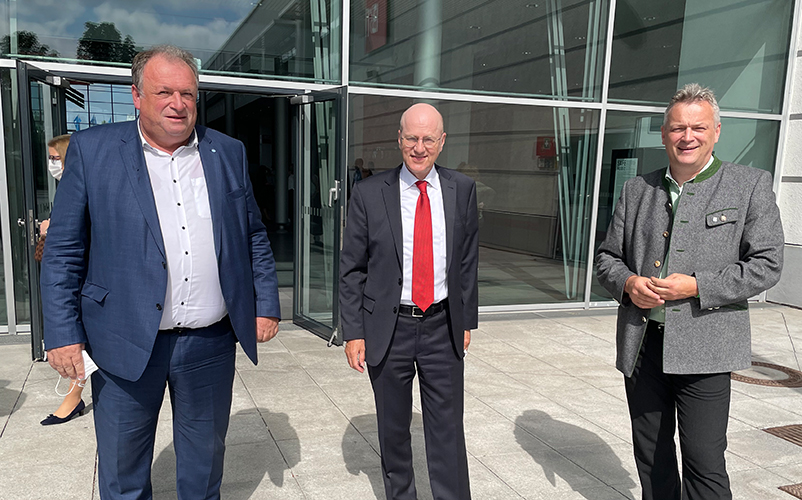 Bürokratieabbaubeauftragter Walter Nussel, Dr. Reinhard Pfeiffer, stellvertretender Vorsitzender der Geschäftsführung bei der Messe München, und Staatssekretär Weigert, StMWi vor dem Eingang zum Messegelände